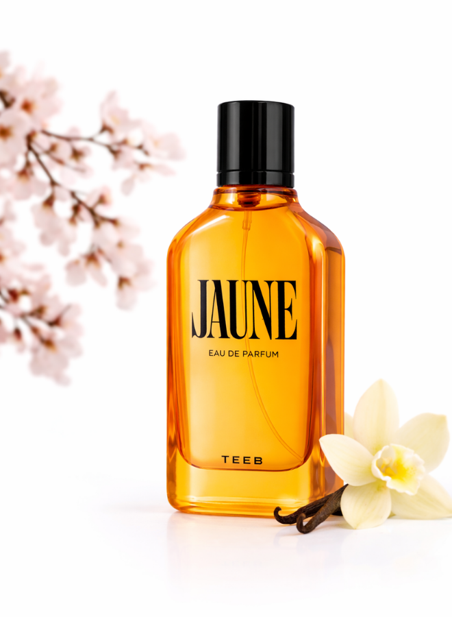 Jaune Eau de Parfum amber-orange bottle with white blossom branches and a vanilla flower