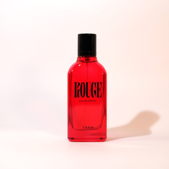Rouge Eau de Parfum 100 ml, red glass bottle with black cap on a warm ivory background