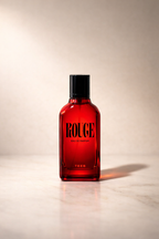 Rouge Eau de Parfum red bottle with black cap on a pale marble surface